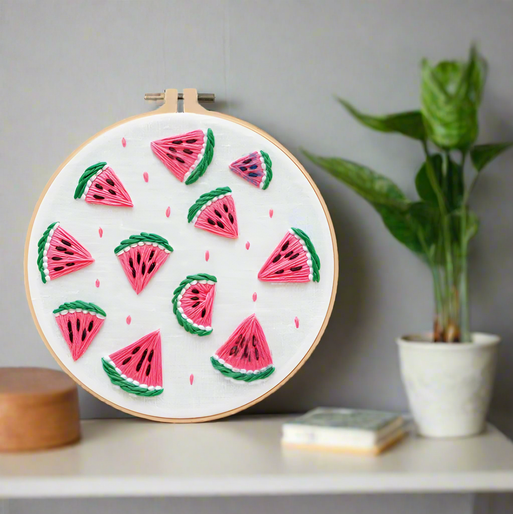 Embroidery DIY art kit with watermelon design, hoop, needles, and thread on a white background