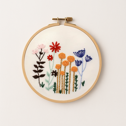 Embroidery hoop with fall embroidery flowers in orange, pink, red and blue