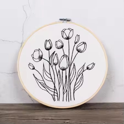 Embroidery hoop with black floral design on a white background